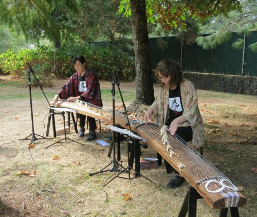 Two musicians play traditional Japanese stringed instruments